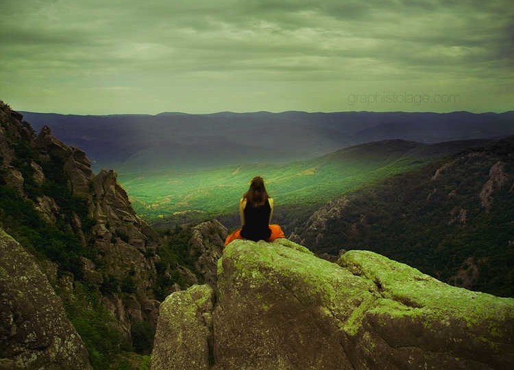 Woman meditating high on a mountain